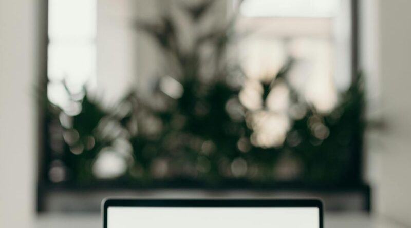 Laptop pe birou intr-un spatiu luminos si minimalist
